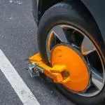 yellow wheel clamp locked with messing lock on an illegally park950x575
