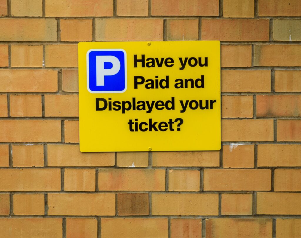 Yellow,Parking,Enforcement,Sign,On,A,Brick,Wall,With,A
