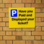 Yellow,Parking,Enforcement,Sign,On,A,Brick,Wall,With,A